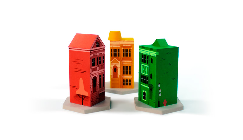 3 colorful game tokens in the shape of San Francisco apartment houses
