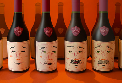 A shelf of wine bottles, each with a label that shows a face aging from childhood to old age