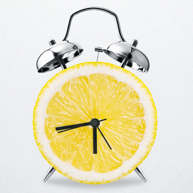 A chrome and sliced lemon alarm clock on a white background.